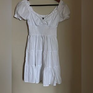 White Cap Sleeve Mini Dress with ruffled trimming and smocked waist.